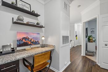 a home office with a desk with a computer on it and a hallway with a
